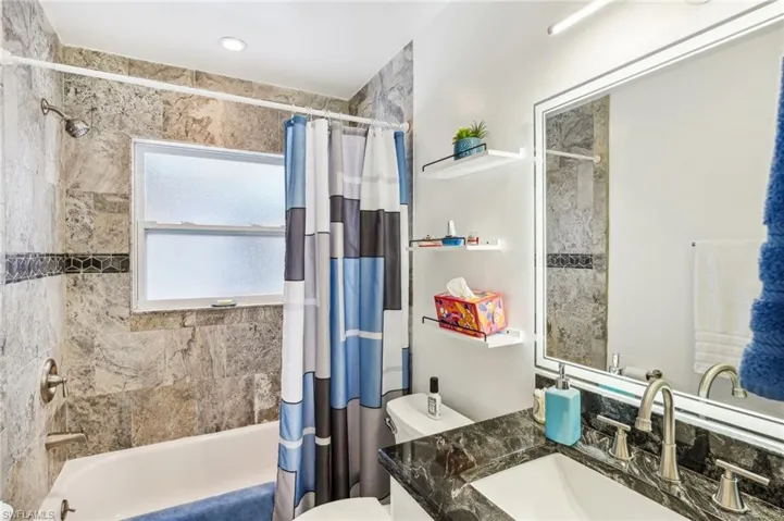 Bathroom with, shower / bath combo  featuring a LED dimmable and fog free mirror
