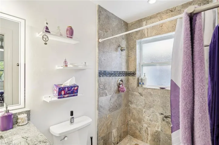 ensuite bathroom with a shower featuring an LED dimmable and fog free mirror