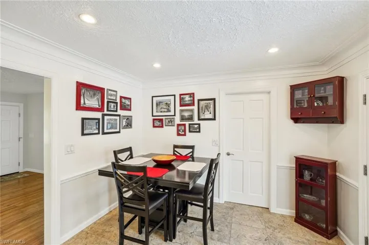 Eat in kitchen/ dining area featuring crown molding and recessed lighting with travertine tiled floors