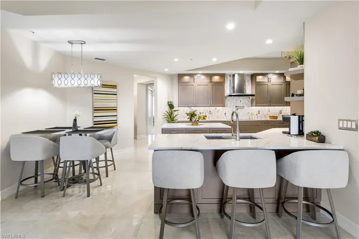 This remodeled kitchen offers a new design! Custom wood cabinetry, underlighting, quartz countertops, island and bar seating.