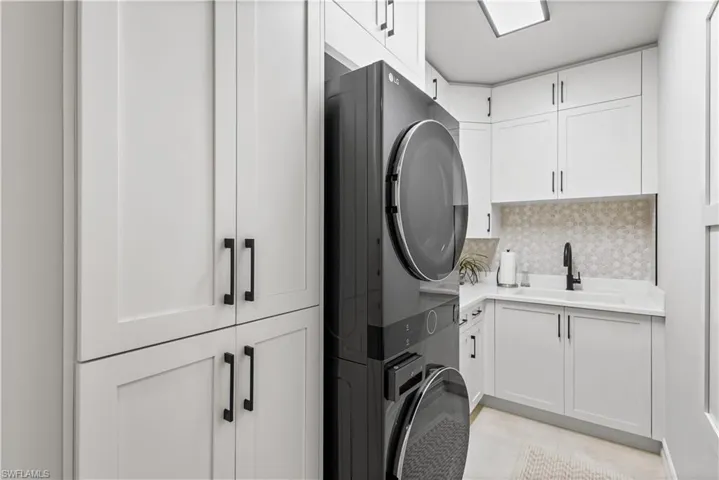 Redesigned laundry room with a full size stack washer and dryer. Lots of storage space.