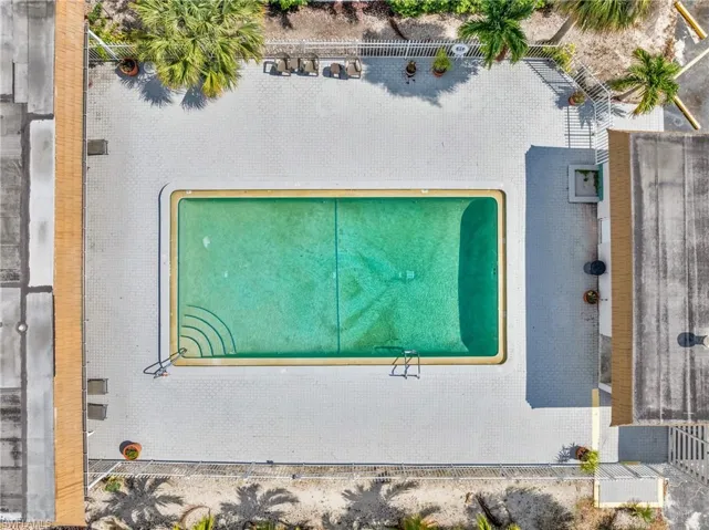 Rectangular swimming pool surrounded by a light-toned paver deck