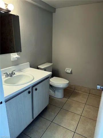 Bathroom featuring a vanity with an integrated sink, dual-handle faucet, wood-finish cabinetry, and a wall-mounted medicine cabinet