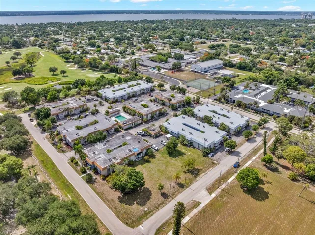 Aerial perspective showcasing a residential community with multiple buildings, paved roadways, and green spaces