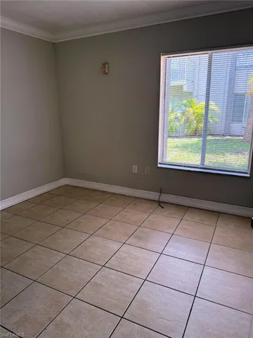 Neutral-toned ceramic tile flooring extending throughout the room