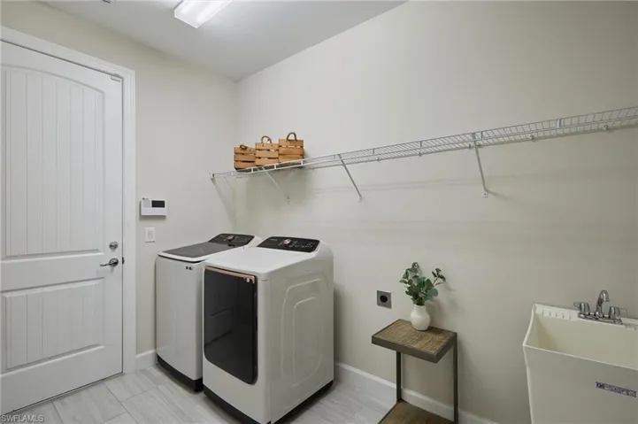 Laundry room with separate washer and dryer and sink