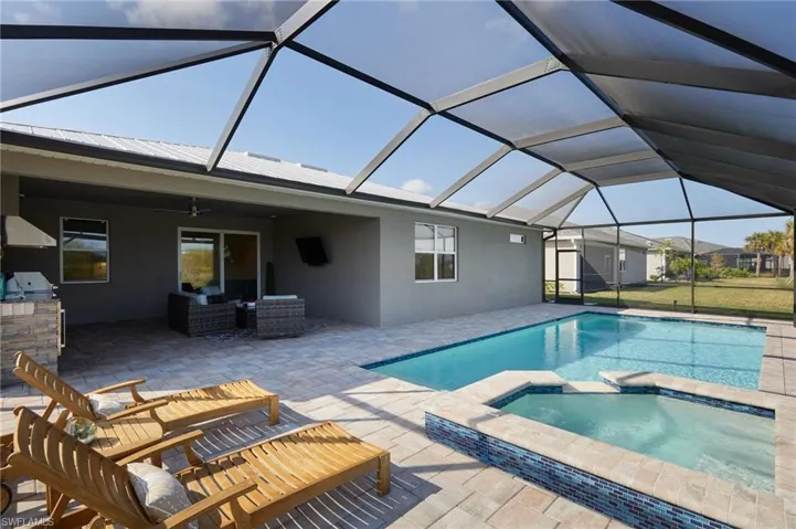 View of swimming pool featuring a patio area and an in ground hot tub