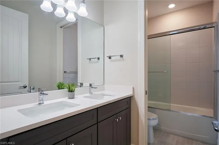 Full bathroom with vanity, toilet, and combined bath / shower with glass door