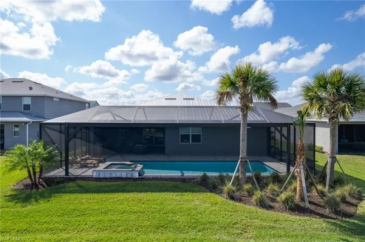 View of pool featuring a lanai, a lawn, and an in ground hot tub
