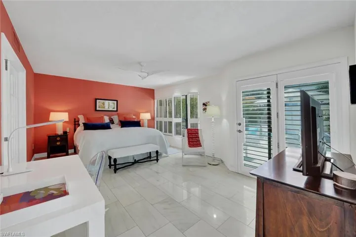 Tiled bedroom featuring ceiling fan and access to outside