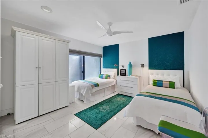 Bedroom with ceiling fan, a closet, and light tile patterned floors