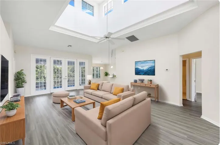 Staged Living room with a high ceiling, french doors, vinyl flooring and lots of natural light