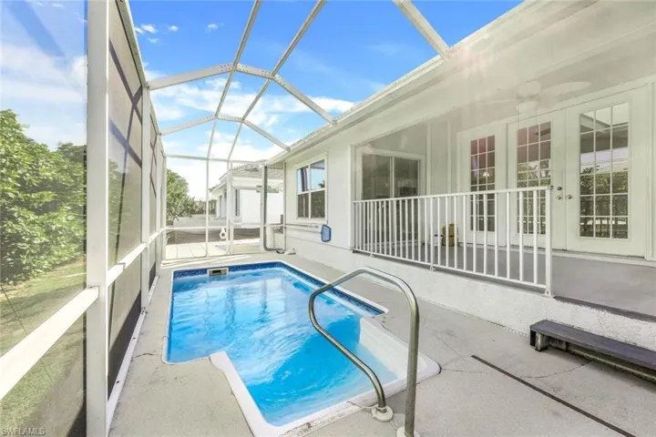 View of swimming pool featuring a lanai, a patio, and a shed