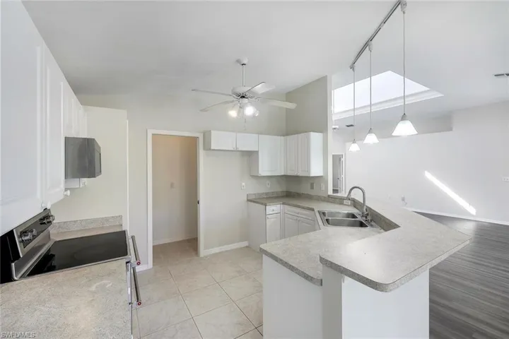 Unfurnished dining area with lofted ceiling, light tile patterned flooring, and a notable chandelier