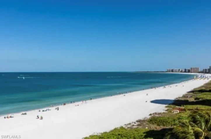 Unfurnished living room featuring french doors, ceiling fan, wood-type flooring, a high ceiling, and a tray ceiling