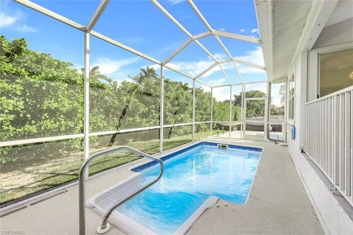 View of swimming pool with ceiling fan, a lanai, and a patio