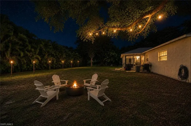 Virtually staged back yard with fire pit and chairs. Bistro lights in the oaks.