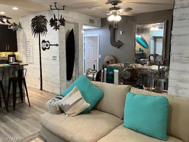 Living room with light wood finished floors and a ceiling fan