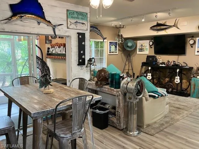 Dining area featuring wood finished floors, track lighting, and a ceiling fan