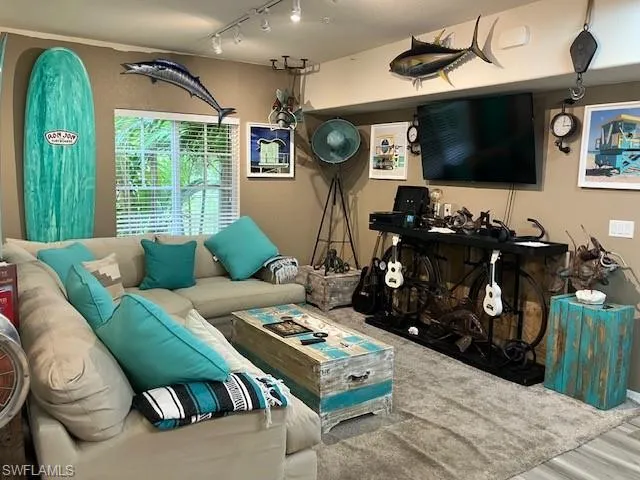 Living area with rail lighting and wood finished floors