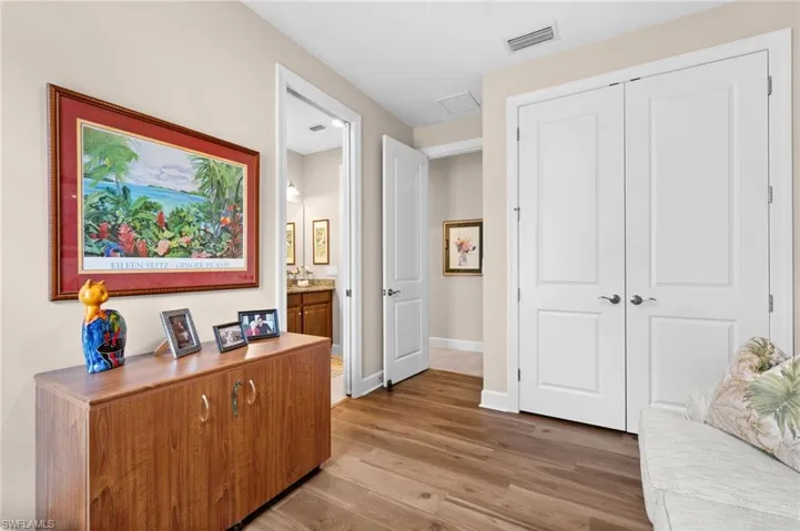 Spacious bedroom featuring wood finish flooring and crown molding