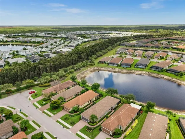 Aerial perspective showcasing a residential community with numerous properties featuring tile roofs and landscaped yards