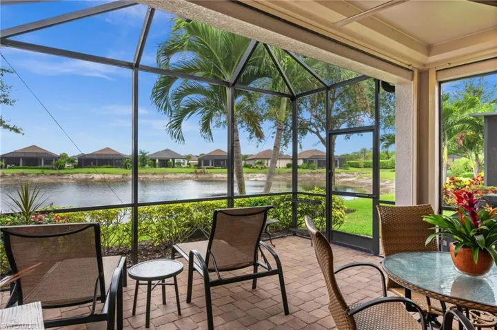 Screened lanai featuring paver flooring, a water view, and established landscaping