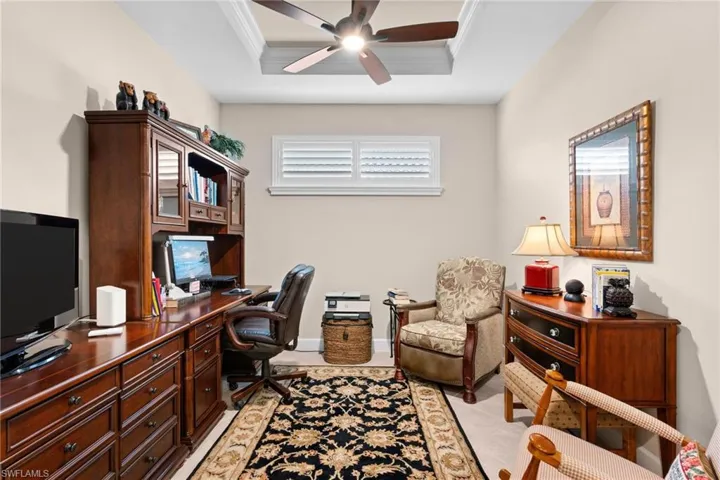 Interior space featuring a recessed ceiling with a ceiling fan, a window with white plantation shutters, and light-toned wall paint