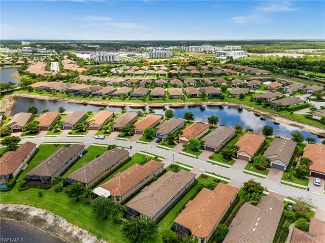 Aerial perspective showcasing a residential community with water features and varied roofing styles