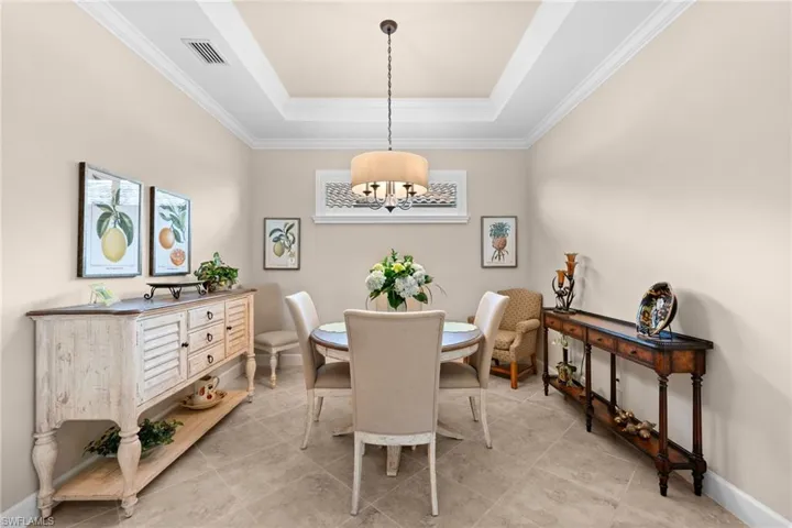 Recessed ceiling tray with crown molding, square tile flooring, and a decorative transom window