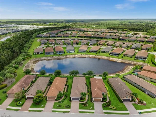 Aerial perspective showcasing a residential community with numerous homes featuring tile roofs and private driveways
