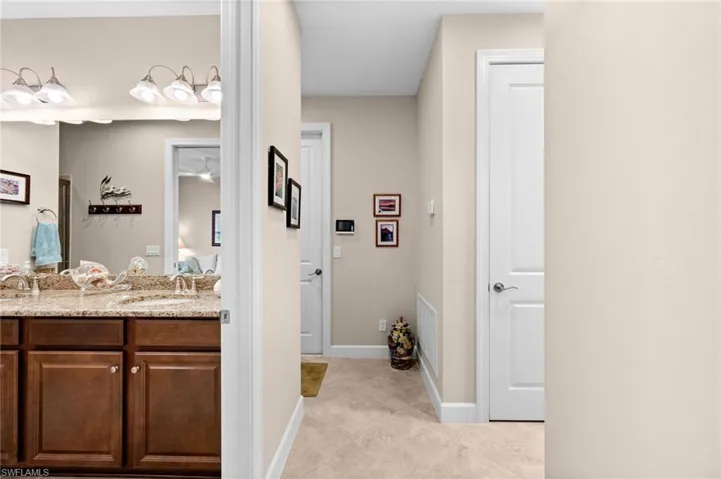 Hallway featuring light-toned walls and tile flooring