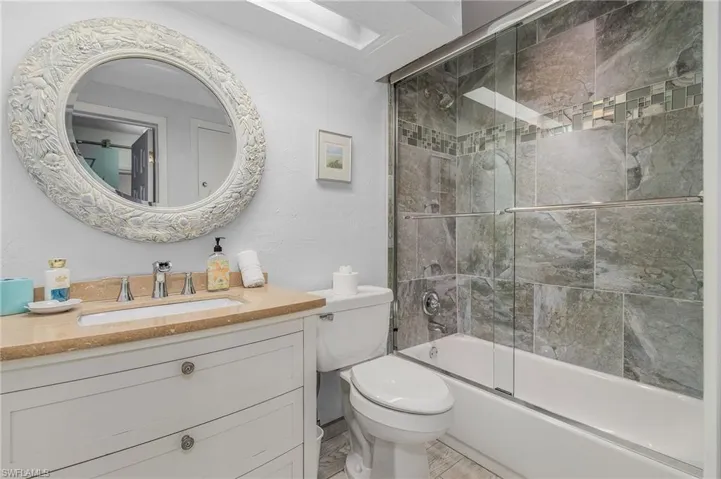 Bathroom with vanity and shower / bath combination with glass door