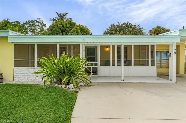 View of front of house with a sunroom and a front lawn