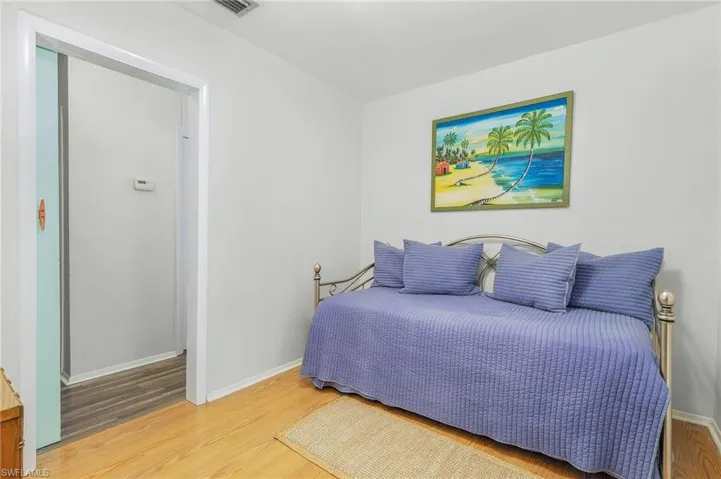Bedroom featuring wood finished floors and baseboards