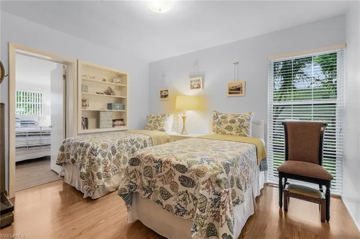 Bedroom with wood finished floors and multiple windows