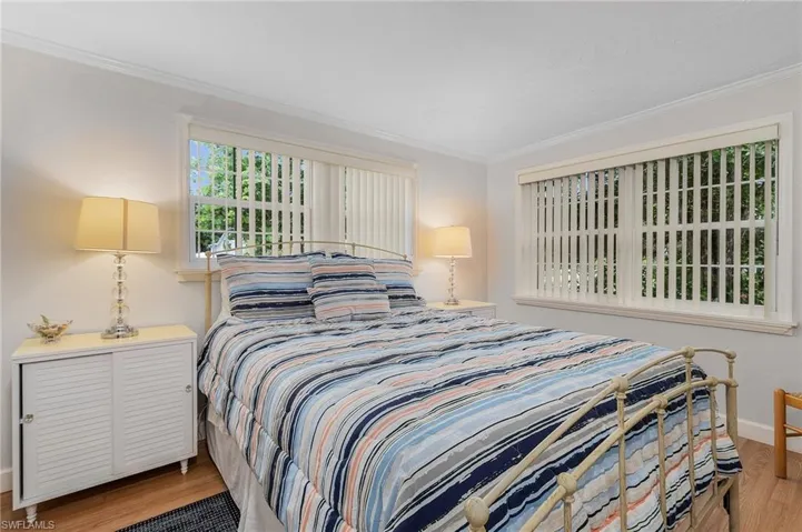 Bedroom featuring light wood finished floors and ornamental molding