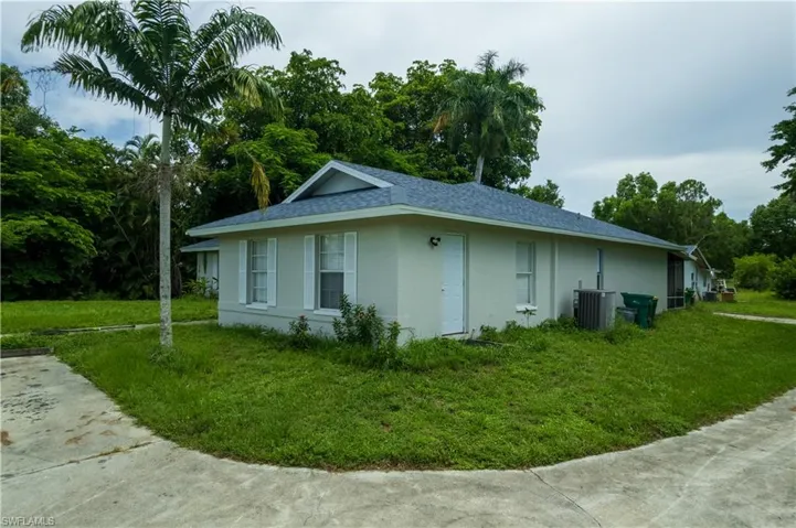 View of property exterior featuring a lawn