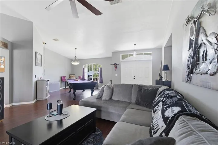 Living room featuring billiards, dark wood-style floors, and a ceiling fan
