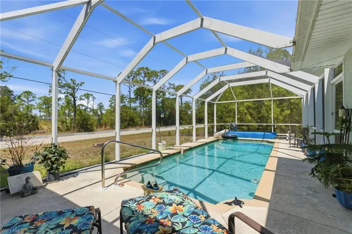 Swimming pool with a lanai, a sunroom, and a patio