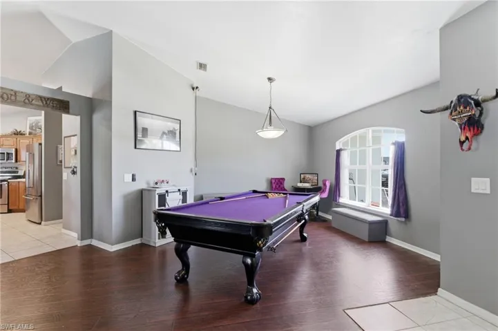 Rec room with lofted ceiling, light wood-style floors, and billiards