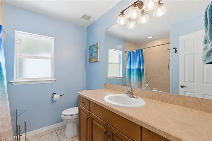 Full bath featuring vanity, light tile patterned floors, and a shower with shower curtain