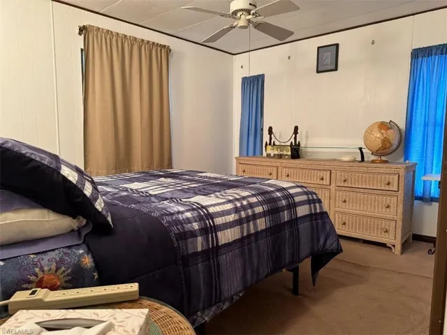 Carpeted bedroom featuring a ceiling fan