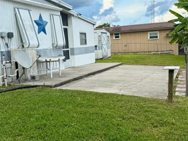 View of yard featuring a storage unit and a patio area