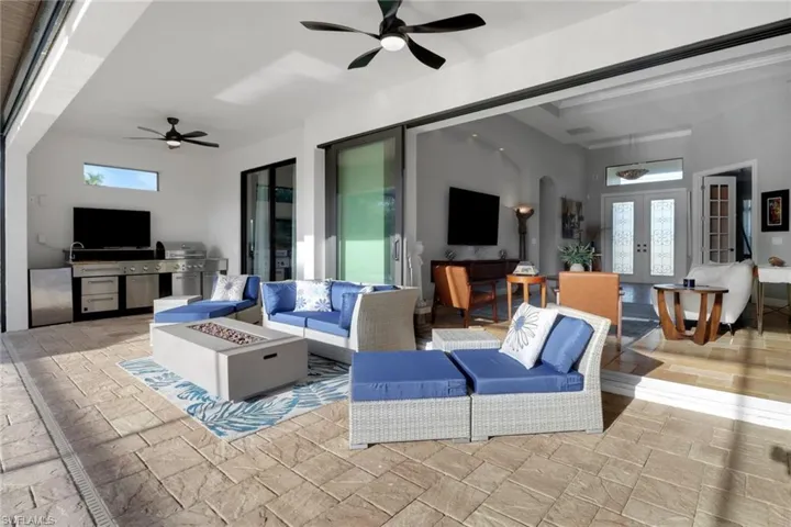 Living area with stone tile flooring, french doors, and a ceiling fan