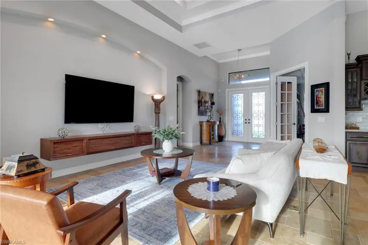 Living area with french doors, arched walkways, and bar