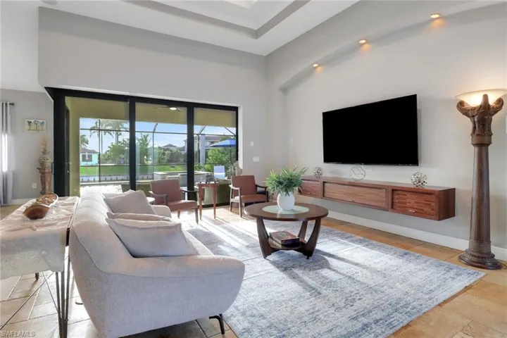 Living room featuring a towering ceiling and baseboards