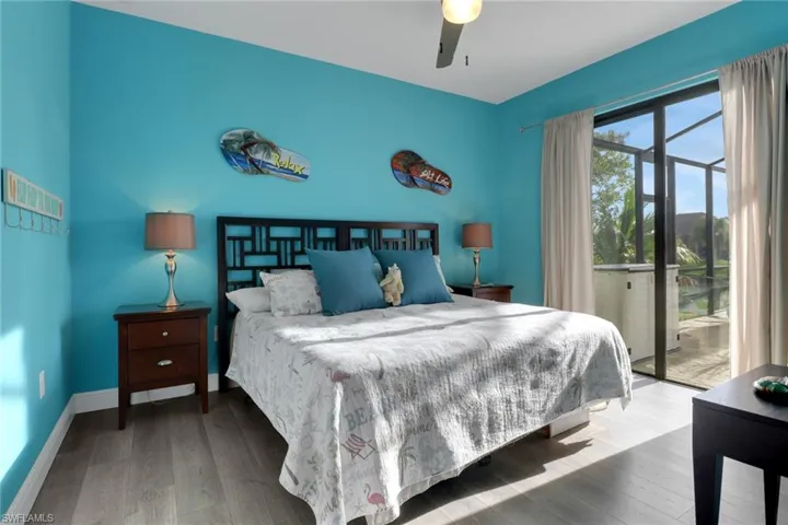 Bedroom with access to outside, wood finished floors, and a ceiling fan