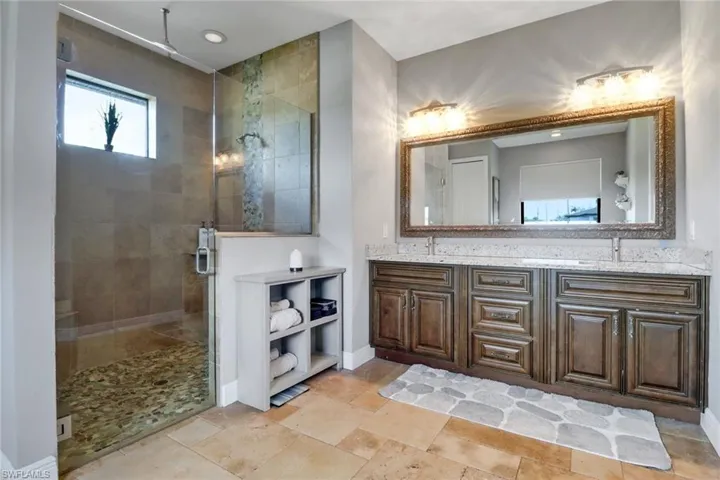 Full bathroom featuring a stall shower and double vanity