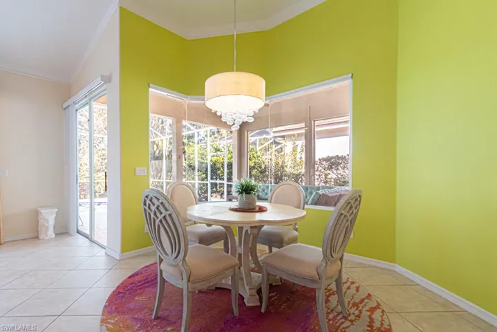 Dining room featuring crown molding, a healthy amount of sunlight, and light tile patterned floors